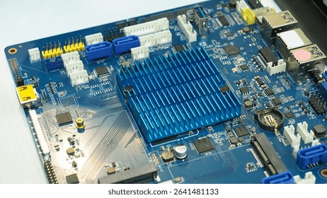 A blue printed circuit board (PCB) with various electronic components