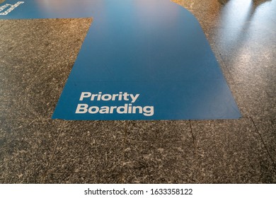 Blue Priority Boarding Lane Painted On Airport Terminal Floor Leading To A Plane Boarding