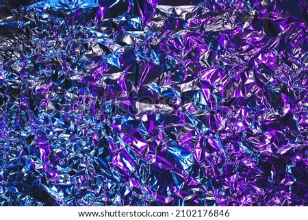Blue and purple aluminum wrinkled foil background. Abstract bright texture reflecting creative gradient. Light neon futuristic colors. Colorful shiny backdrop for screens, website, flyers 