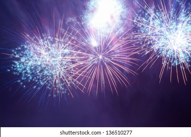 Blue and purple colorful fireworks on the black sky background. Holiday celebration.