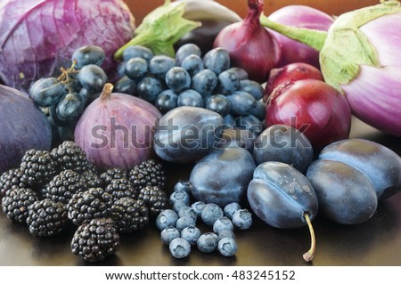 Blue and purple food. Berries, fruits and vegetables on a black background.            