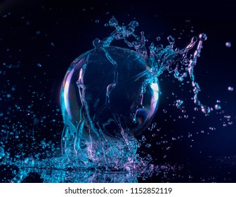 Blue And Purple Water Splashing On A Transparent Ball In A Dark Background