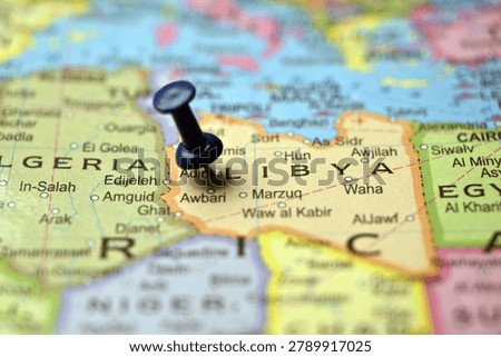 Blue Push Pin Marking Libya on Blurred World Map Macro Close Up Travel Backgrounds