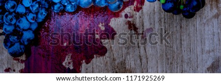 Blue rape berries and red grape natural juice on wooden background. New vintage wine background. Red wine made from such grapes, banner
