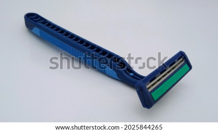blue razor with safety sharp blade to cut men's  beard  and womans  body care for beauty. this personal equipment closeup in isolated white background 