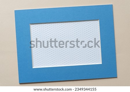 blue rectangle mat board frame with bevel cut and paper on blank beige paper