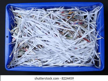 Blue Recycle Bin With Shredded Paper Inside