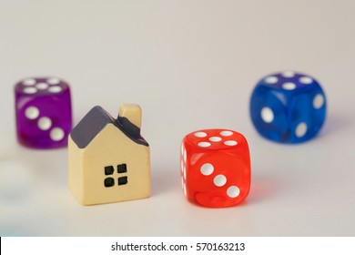 Blue And Red Dice And Small Yellow Toy House On A White Background