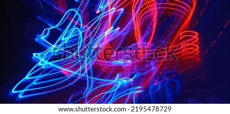 Blue and red light painting photography, long exposure fairy blue and red lights curves and waves against a black background. Abstract motion curvy urban road with neon light motion effect applied .