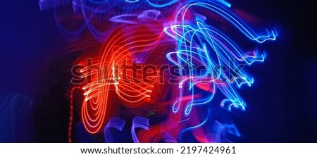 Blue and red light painting photography, long exposure ripples and waves pattern against a black background. Light trails long exposure highway. Blue and gold light painting photography, long exposure