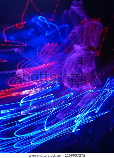 Blue and red light painting photography, long\
exposure fairy blue and red lights curves and waves against a black\
background. Long exposure light painting photography. Abstract pink\
purple swirls