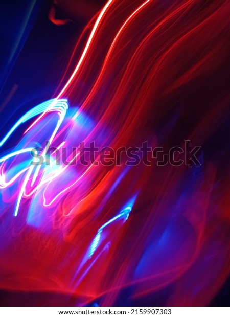 Blue and red light painting photography, long\
exposure fairy blue and red lights curves and waves against a black\
background. Long exposure light painting photography. Abstract pink\
purple swirls