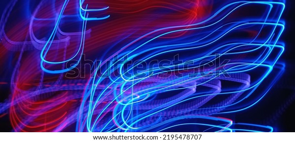 Blue and red light painting photography, long exposure\
fairy blue and red lights curves and waves against a black\
background. Abstract motion curvy urban road with neon light motion\
effect applied .