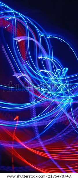 Blue and red light painting photography, long exposure
fairy blue and red lights curves and waves against a black
background. Abstract motion curvy urban road with neon light motion
effect applied .