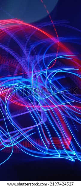 Blue and red light painting photography, long\
exposure fairy blue and red lights curves and waves against a black\
background. Long exposure light painting photography. Abstract pink\
purple swirls\
