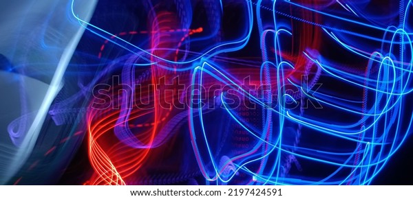 Blue and red light painting photography, long\
exposure fairy blue and red lights curves and waves against a black\
background. Long exposure light painting photography. Abstract pink\
purple swirls\
