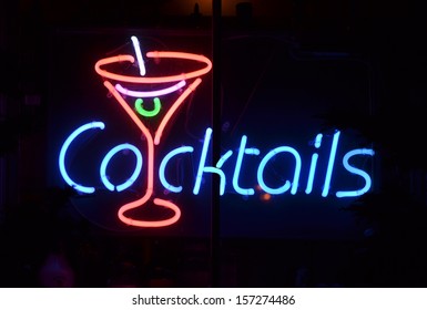 A blue and red neon sign reading Cocktails - Powered by Shutterstock