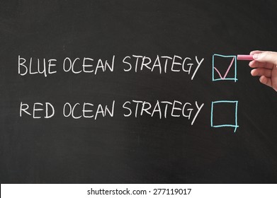 Blue or red ocean strategy words written on the blackboard using chalk