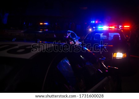 Blue and red police lights on squad cars during a night time traffic stop, with space for text on the left
