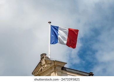 Blue red white french flag on roof of ciry hall in France and sky on background - Powered by Shutterstock