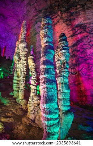 Blue, red and yellow stalactite columns in Huanglong cave (name of the cave), Wulingyuan Scenic Area, Zhangjiajie, Hunan, China. Colorful rocks, million years cave, beautiful lighting