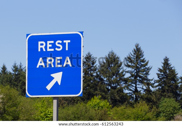 Blue rest area sign points to a\
highway exit where drivers can relax and rest during their\
travel.