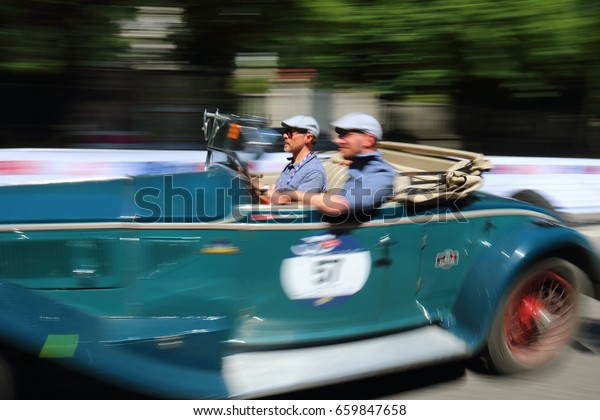 Blue retro\
car with two pilots at speed. Finish event 1000 Miles Annual race\
of retro auto. Brescia Italy May 21\
2017