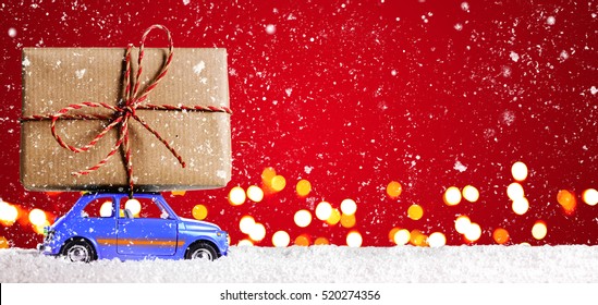 Blue Retro Toy Car Delivering Christmas Or New Year Gifts On Festive Red Background