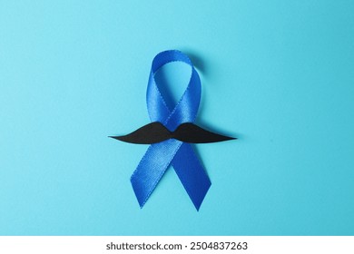 Blue ribbon and fake mustache on color background, top view. Prostate cancer awareness - Powered by Shutterstock