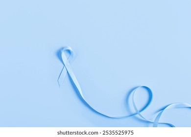 A blue ribbon on a darker blue surface, symbolizing support for colorectal cancer. Clean and professional, ideal for medical campaigns and advocacy projects. - Powered by Shutterstock