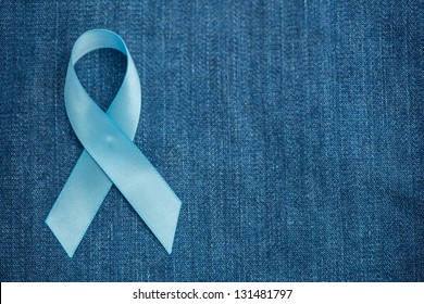 Blue ribbon for prostate cancer awareness on blue demin with copyspace - Powered by Shutterstock