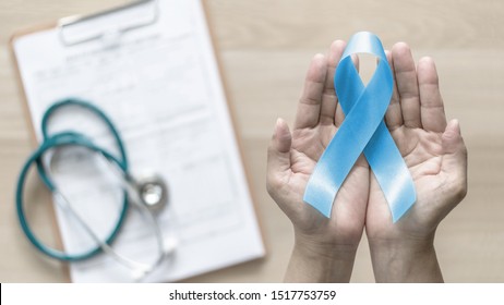Blue ribbon for prostate cancer awareness and men's health care concept with bow color in doctor support or patient hands