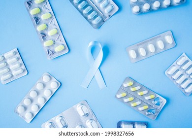 Blue Ribbon Symbol Of Prostate Cancer With Many Pills And Drugs Clusters On Bright Background. Cancer Awareness, Cure, Treatment Concept. Oncology And Carcinoma, Ribbon