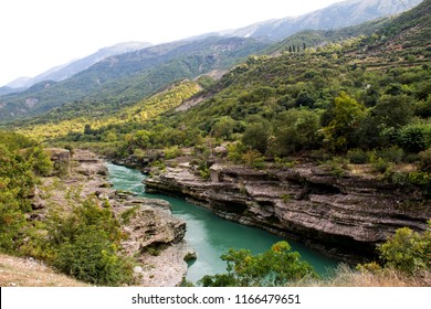 A Blue River Flowing Through The Landscape In Permet District Of Albania.
