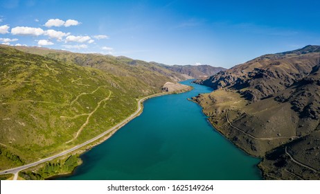 Blue river and road an a side inside a valley aerial view