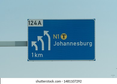 blue road sign and directions on the N1 highway showing white arrows turning to the city of Johannesburg in South Africa