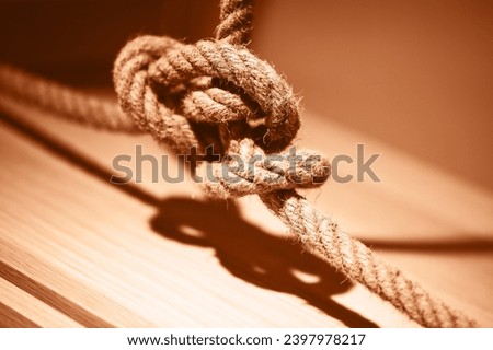 Blue rope tied up in a knot. Demonstrating color of the year 2024.