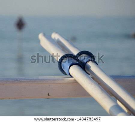 the blue rowlocks of two wooden oars under the summer sun rays