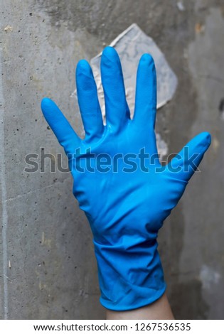 blue rubber glove in the background of a concrete wall