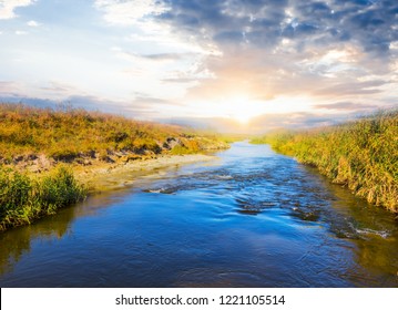 Blue Rushing River At The Sunset