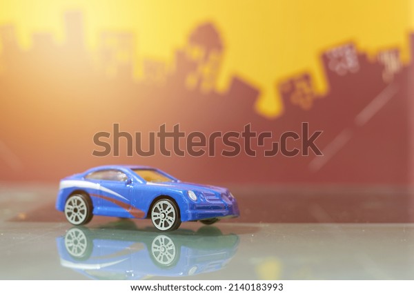 Blue saloon car toy selective focus on blur\
city background