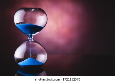 Blue sand hourglass on old background