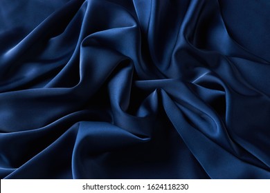 Blue sapphire color silk fabric background, top view. Smooth elegant blue silk or satin luxury cloth texture can use as abstract background with copy space