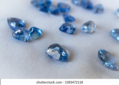 Blue sapphire isolated on white background, closeup and selective focus.
