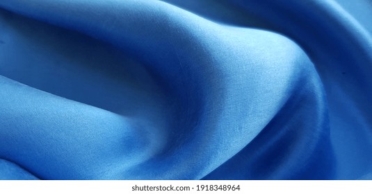 Blue satin fabric in folds (texture).