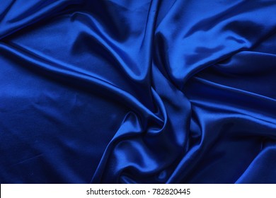 Blue satin, silky fabric, wave, draperies. Beautiful textile backdrop. Close-up. Top view  - Shutterstock ID 782820445