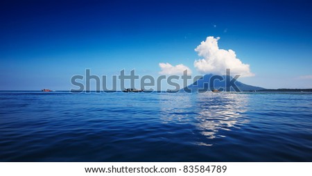 Blue sea with boats and mountain on a horizon. Bunaken marine park. Indonesia