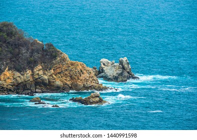 Blue sea with rocky shore in sunny afternoon, Acapulco, Mexico.