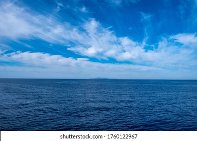 Blue sea and sky background, blue shades horizon. White clouds on clear sky over sea water surface. Tranquil ocean with ripples. Aegean mediterranean sea, Greece - Powered by Shutterstock