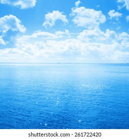 Blue Sea And Sky With White Clouds.